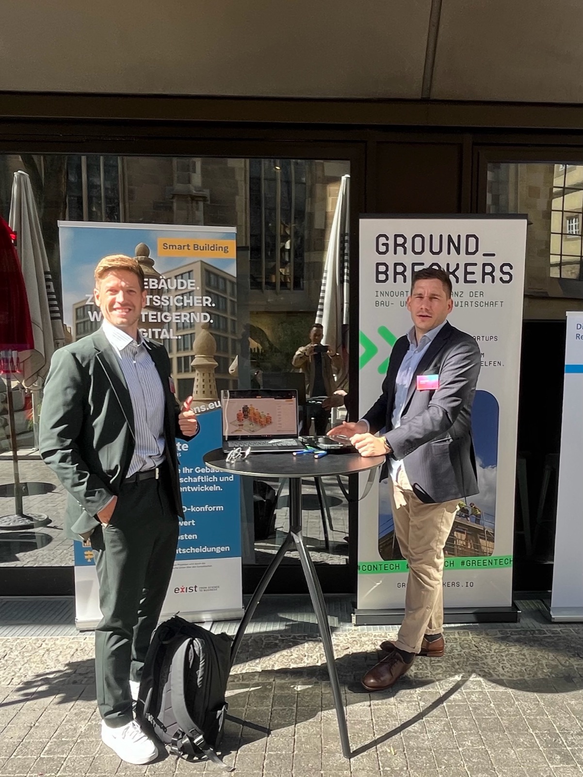 Unser Stand beim Symposium Zukunft Bauen, zwei Personen am Stehtisch vor den Aufstellern von OnSite Solutions und GROUNDBREAKERS